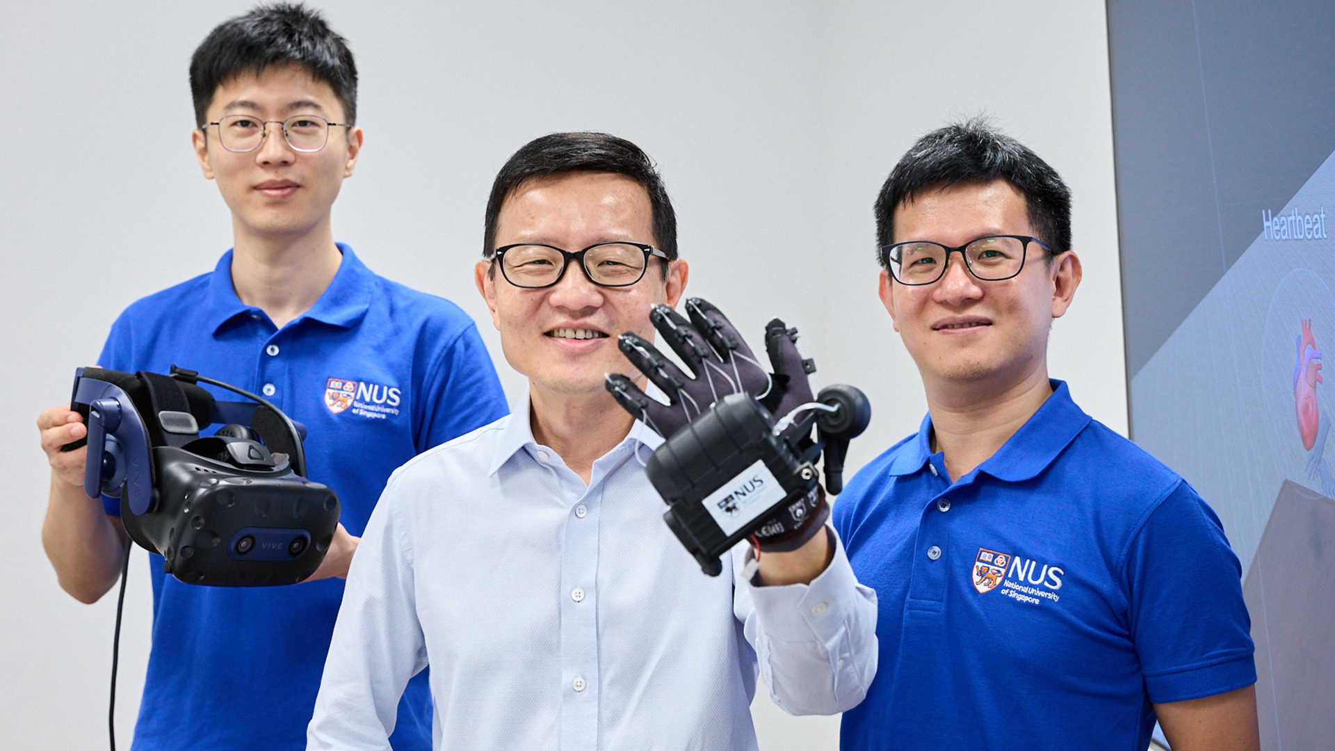 Prof Lim Chwee Teck (centre) with Mr Qi Jiaming (left) and Dr Yeo Joo Chuan (right) from the NUS Institute for Health Innovation & Technology with their new invention - HaptGlove.