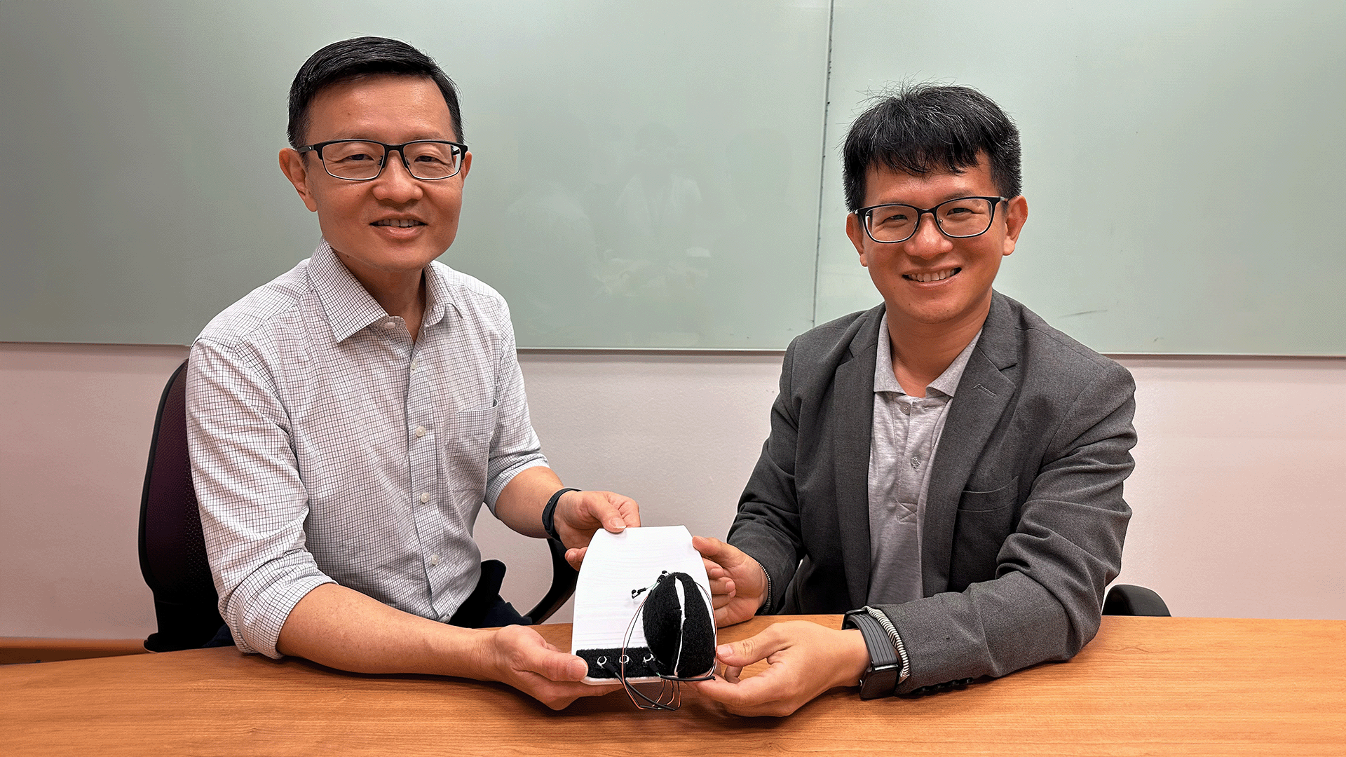 Prof Lim Chwee Teck (left) and Dr Yeo Joo Chuan (right) holding a prototype of the FUNction Device.