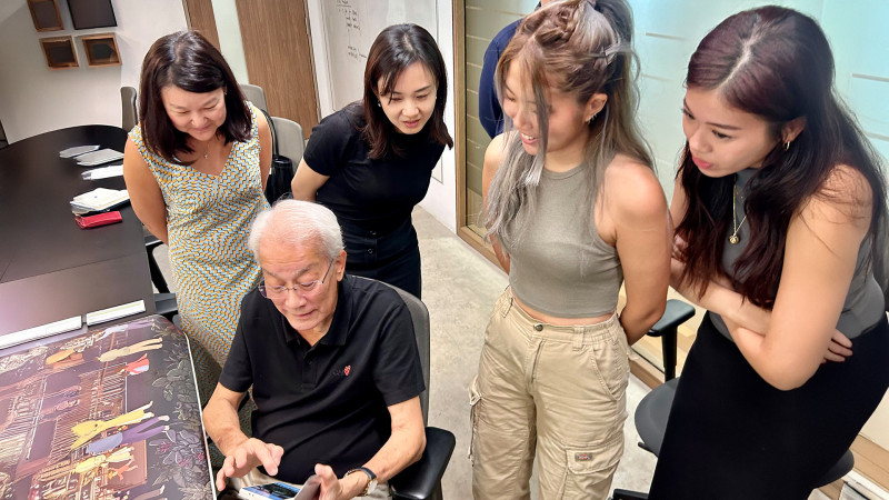 The benefactor of the Edward D’Silva Award, looking at the photos of the award recipients’ overseas research trips made possible by the award.   