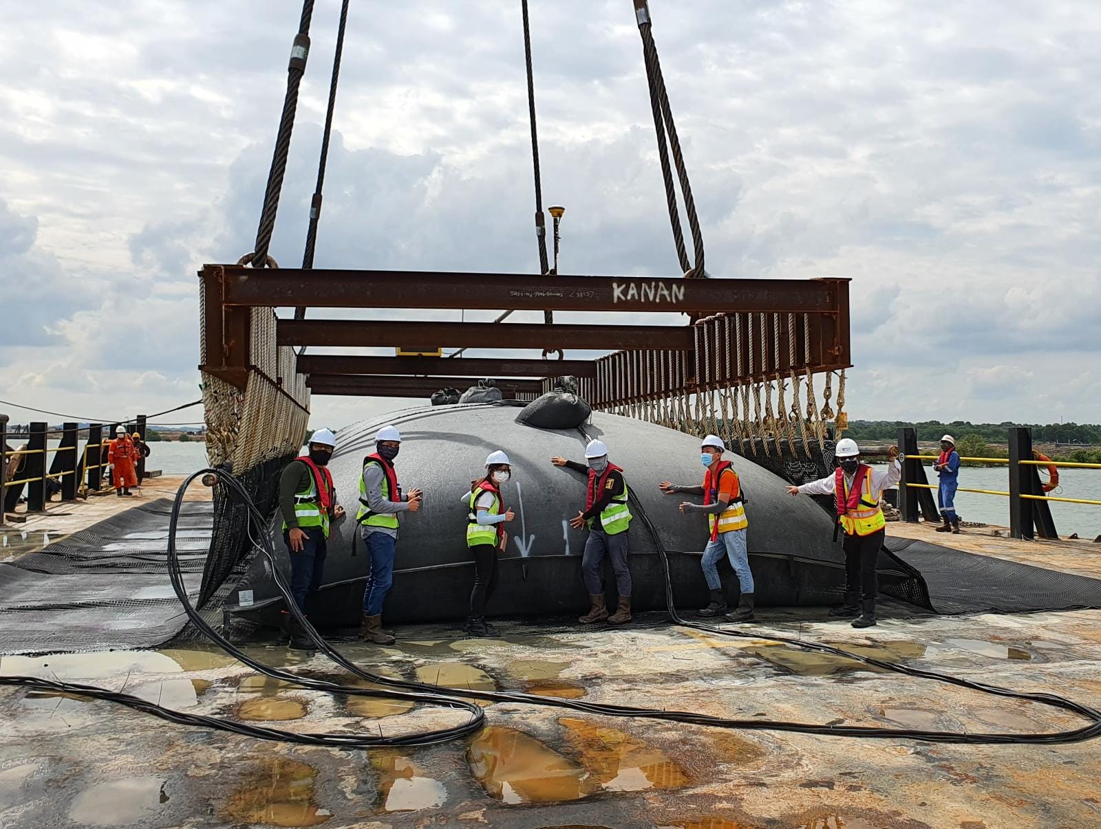 Members of the project team with one of the tubes filled and ready to be lifted into position.