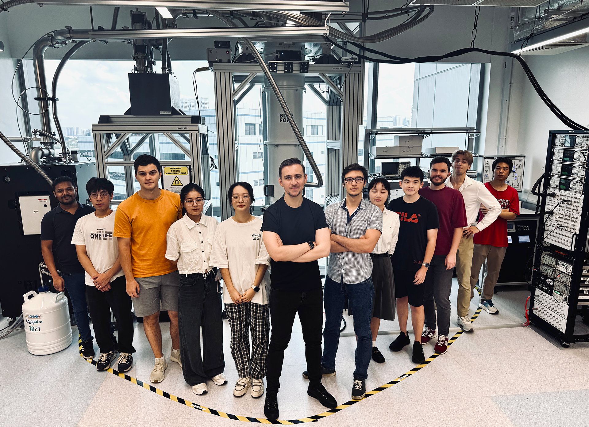 dbartic Asst Prof Denis Bandurin (centre) with members of his research team in their lab. Also pictured are PhD students and first authors of the research paper Mikhail Kravtsov (orange shirt) and Artur Shilov (white shirt, second from right).
