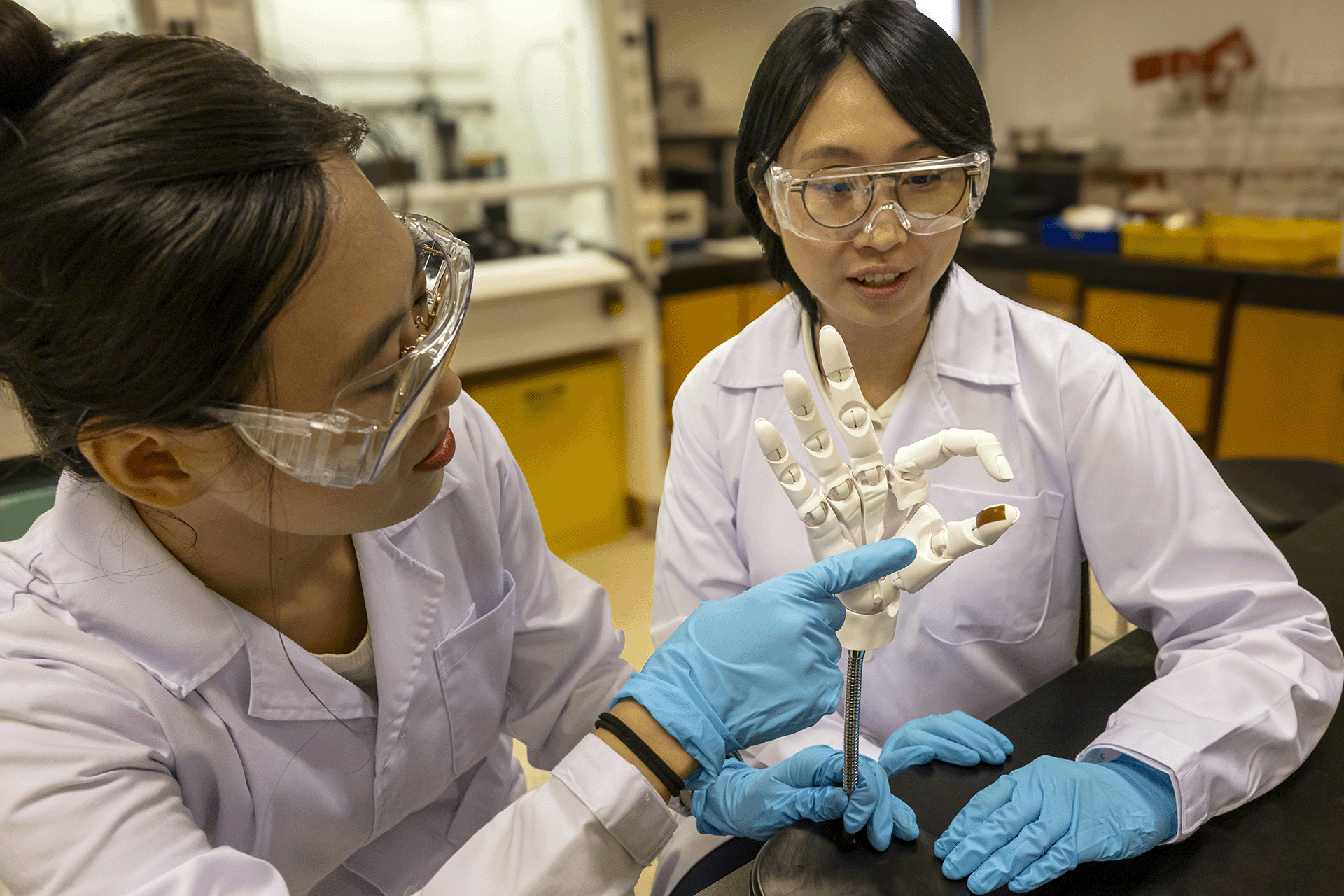 Asst Prof Tan Yu Jun (right) with Dr Zhang Xuan (left), the first author of the research paper, demonstrating use of the MINE material as an e-skin.