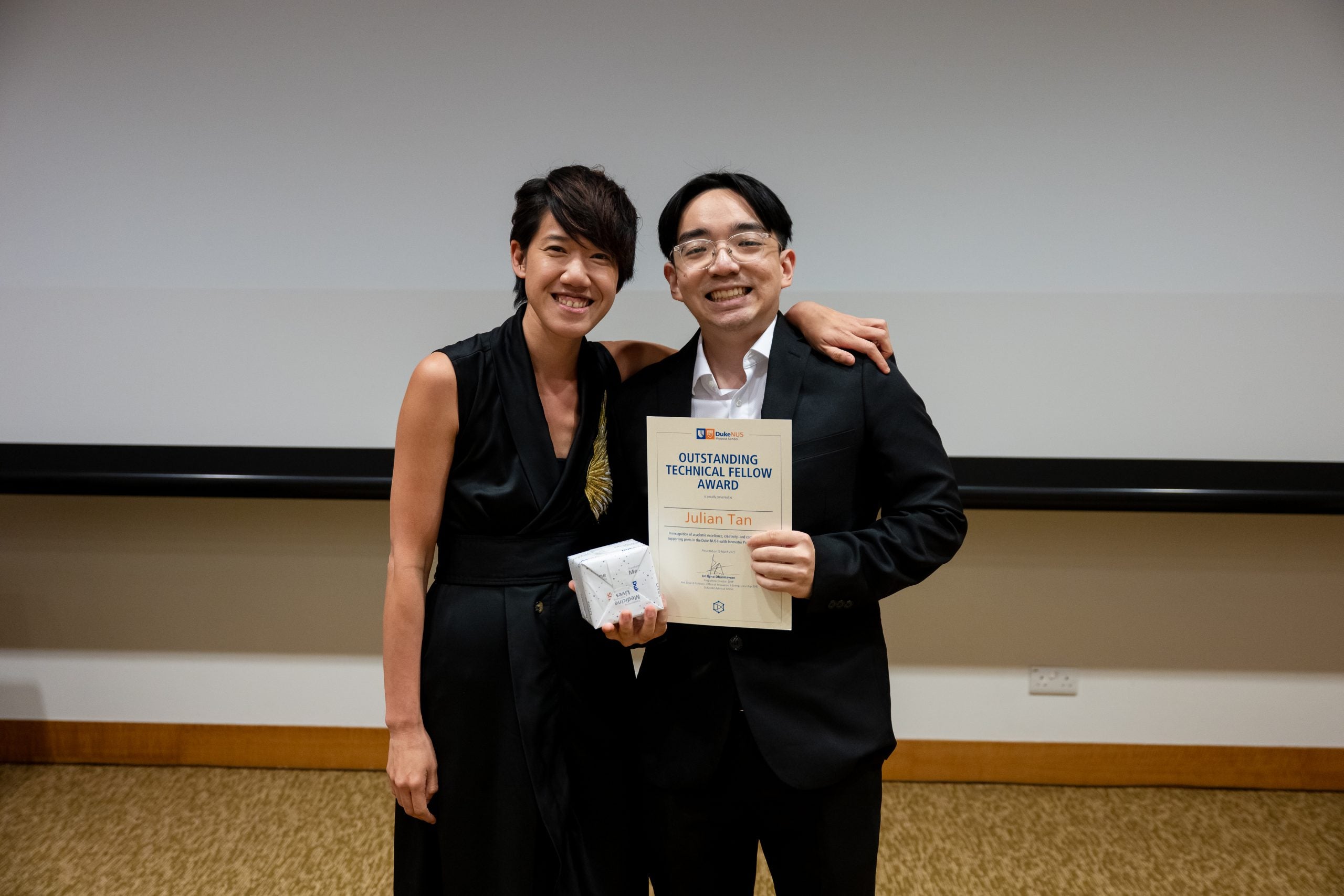 Outstanding Technical Fellow Julian Tan receiving the “Outstanding Technical Fellow Award” from A/Prof Rena Dharmawan