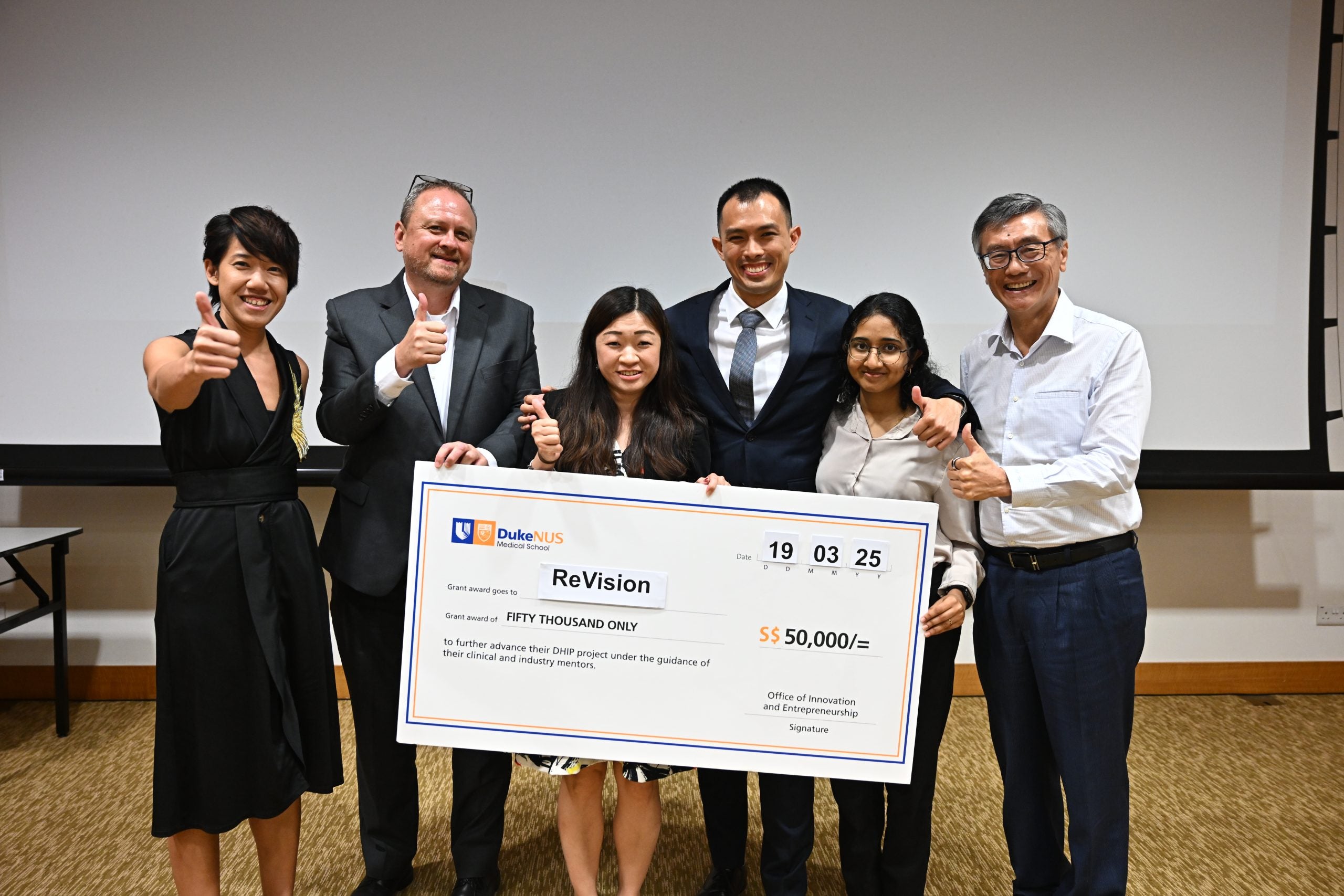 Winning Team ReVision 2 From left to right: A/Prof Rena Dharmawan, Assistant Dean for Innovation Education and Ecosystem Development at Duke-NUS; A/Prof Christopher Laing, Vice-Dean, Office of Innovation & Entrepreneurship at Duke-NUS; Team ReVision, comprising NUS business school MBA student Kwok Ka Po Melody, Duke-NUS MD students Charles Yau and CDE biomedical engineering student Lakshmi Sujeesh; and Guest-of-Honour, Professor Tan Eng Chye, NUS President.