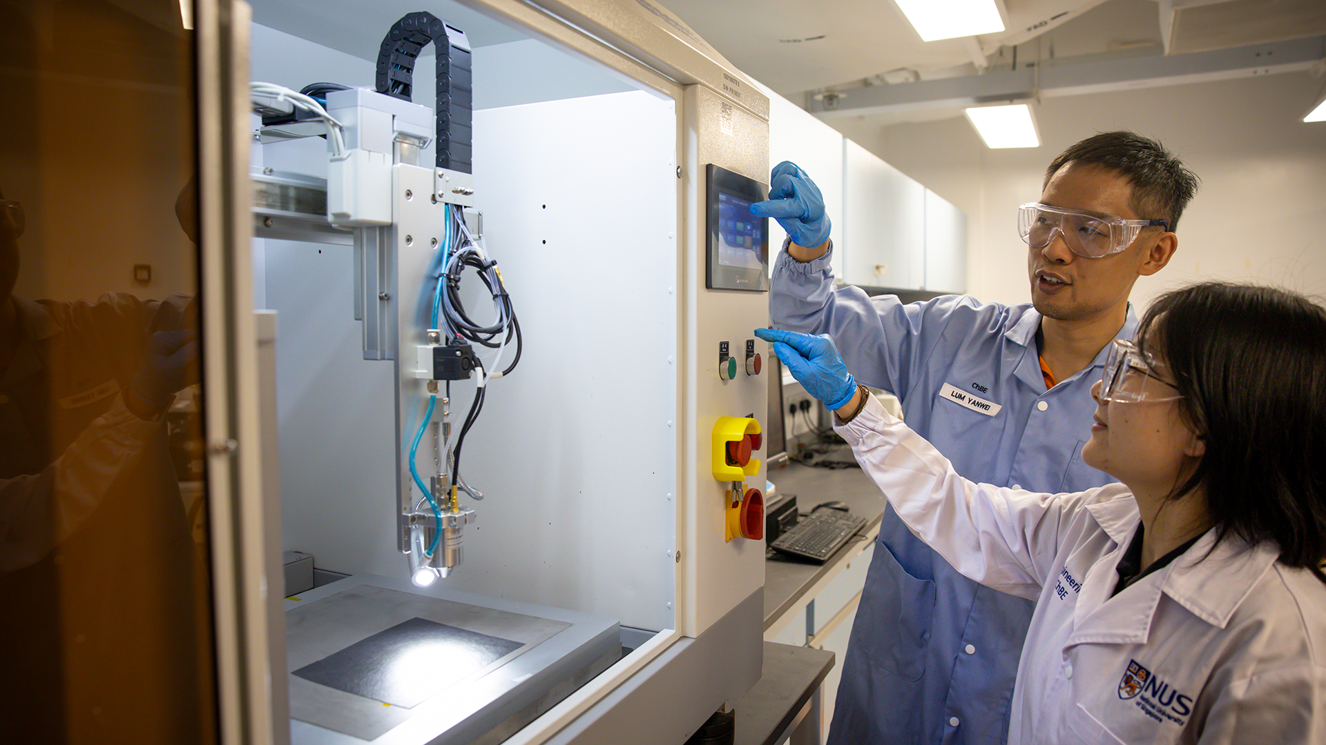 The researchers with an ultrasonic spray coating machine used to deposit the catalyst material onto the electrode.