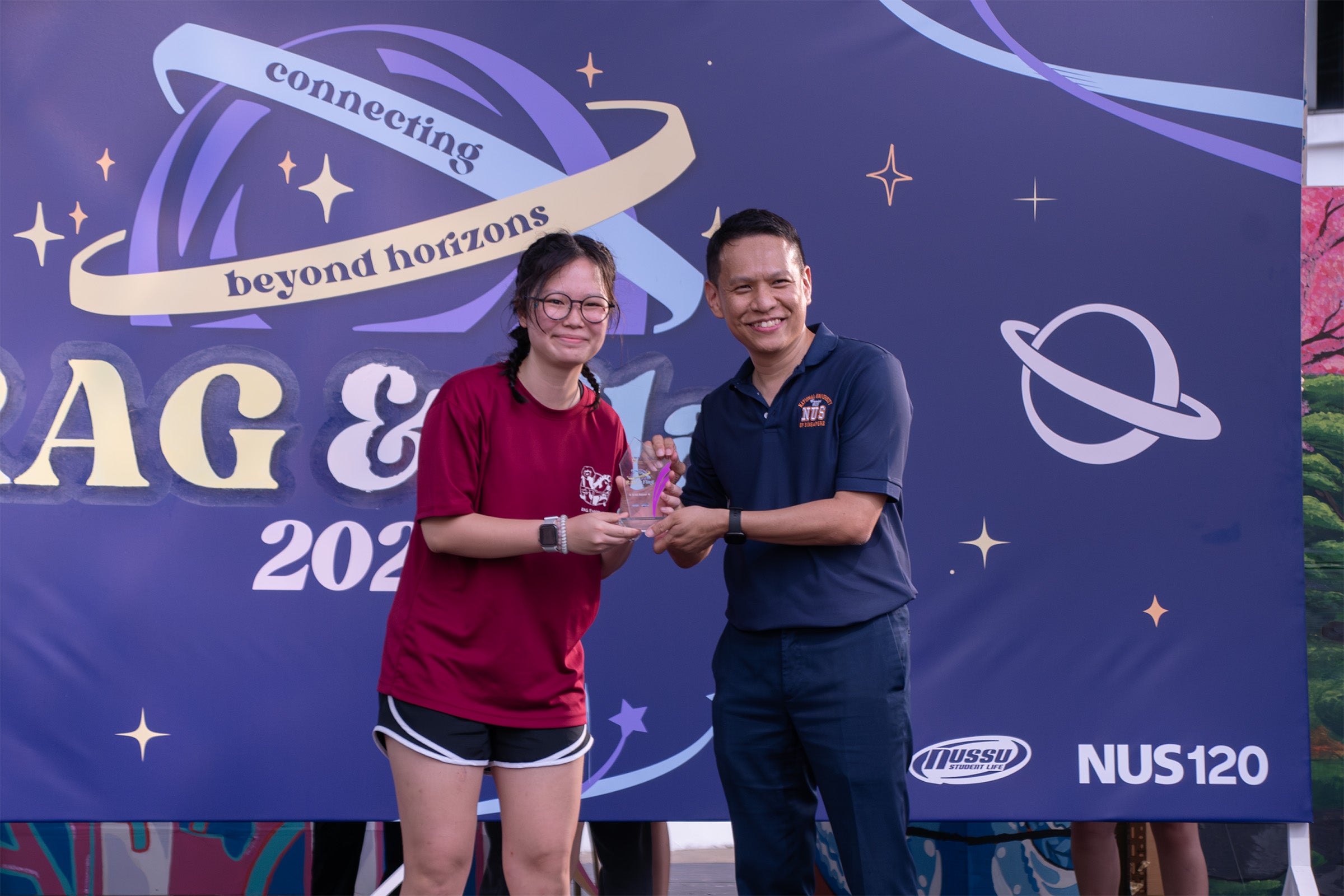 Ho Jing En Cheryl (Year 2 Biomedical Engineering), Project Director of CDE Rag receiving the Silver Award from Associate Professor Ho Han Kiat (Dean of Students, Office of Student Affairs)