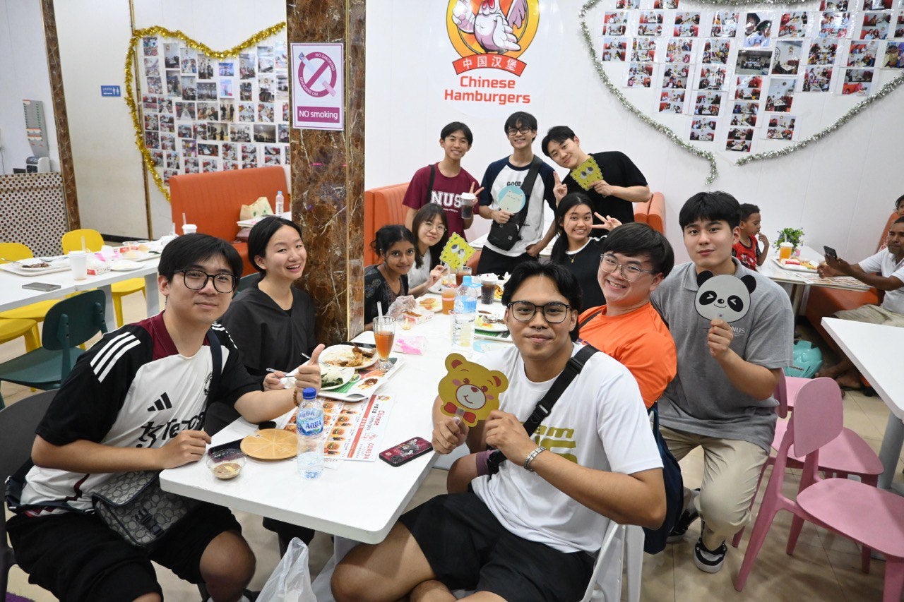 Students enjoying a meal at a Chinese hamburger shop are delighted to learn that the owner is from the same district as one of them.