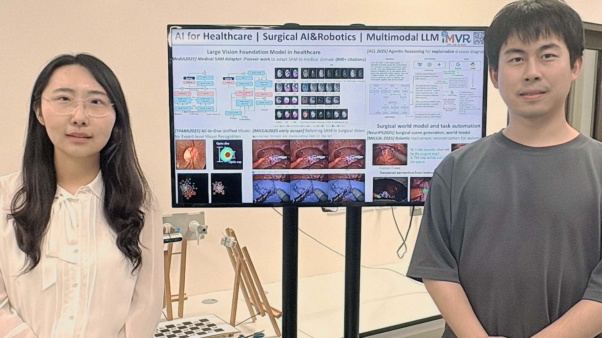 Asst Prof Jin Yueming (left) and a member of her research team with visual outputs from the Medical SAM Adapter, illustrating their applied research in medical AI perception and clinical decision support.