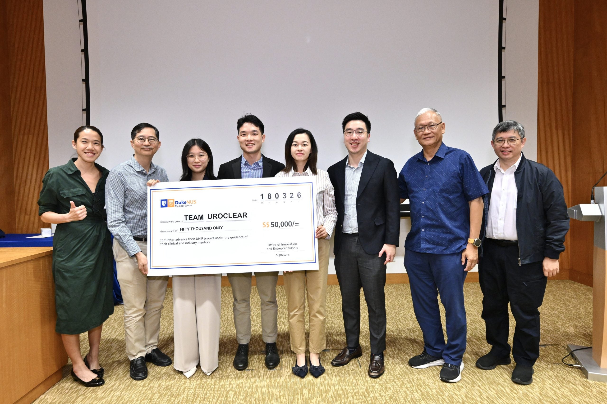 (L – R) Assistant Professor Rena Dharmawan, Assistant Dean, Office of Innovation and Entrepreneurship, Duke-NUS; Professor Patrick Tan, Dean, Duke-NUS; Team UroClear, comprising NUS Biomedical Engineering student Ooi Jie Min, Duke-NUS MD student Danny Lo, NUS MBA student Joyce Zhang; Dr Alvin Lee, Associate Consultant, Urology, SGH, and Peter Cheng, Advisor, Zig Ventures; and Guest-of-Honour, Professor Kenneth Mak, Director-General of Health, Ministry of Health. // Image credit: Duke-NUS Medical School