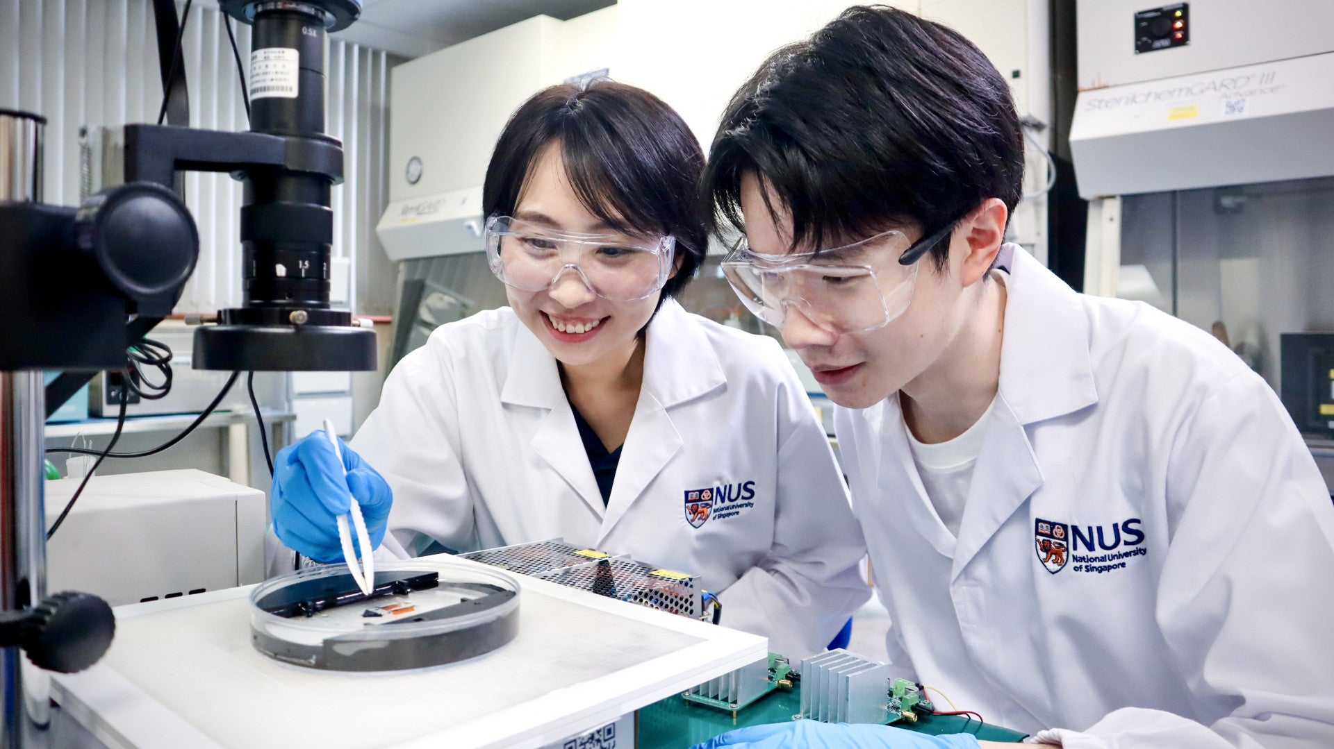 Asst Prof Tan Yu Jun (left), PhD student Mr Zhou Jinrun (right) at work in lab.