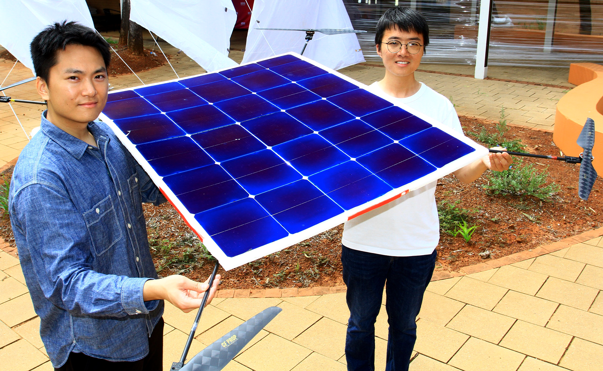 Project leader Zhang Dewen (right) and Yuan Zifeng (left), both PhD students from Electrical and Computer Engineering, with their solar-powered drone at the test site in Alice Springs, Australia. (Photo: Centralian Today, Alice Springs/Phil Williams) 