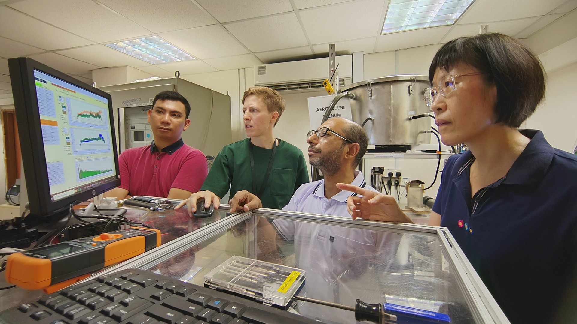 Assoc Prof Yu (right) and members of her research team at work in an air quality lab detecting composition of ambient aerosols.