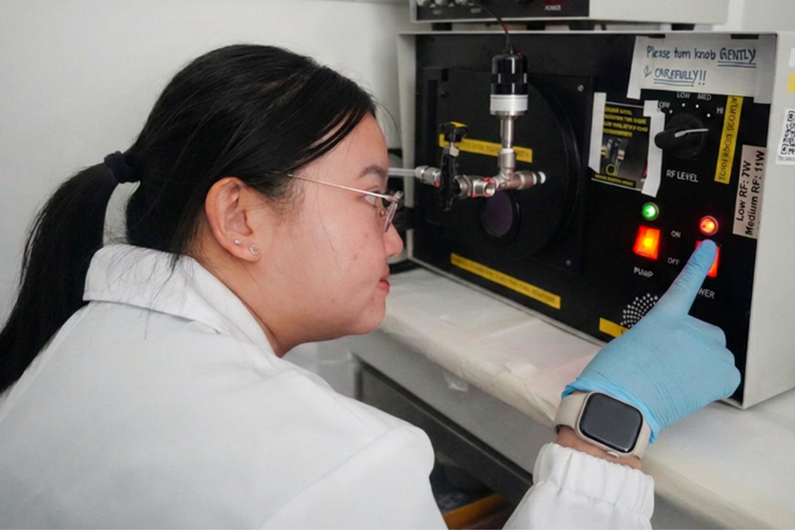 PhD student Nicole Lee Jia Wen using a plasma machine to assemble the microchannel devices used for confined migration experiments.