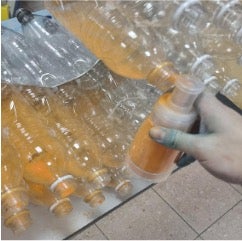 Application of color by dusting the interior of the bottles with Holi powder