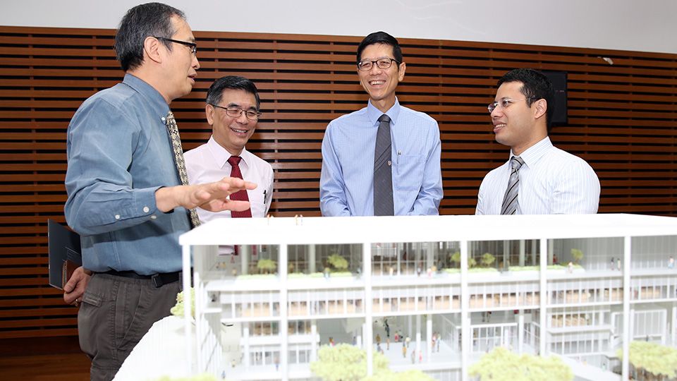 From left: Former Dean of SDE Prof Heng Chye Kiang, Prof Lam, Prof Tan and Mr Lee viewing the model of the new building