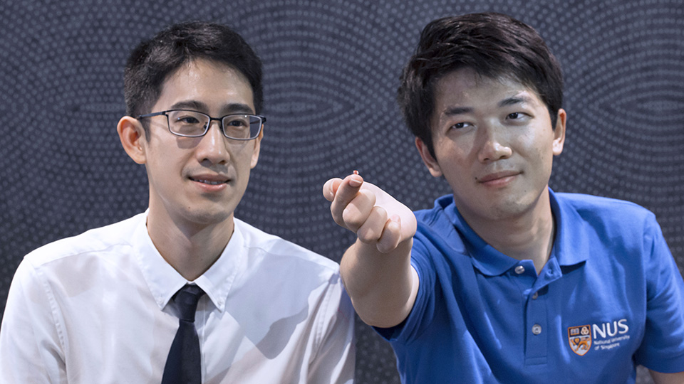 <div>The advanced wireless technology developed by Asst Prof John Ho (left) and doctoral student Dong Zhenya (right) can sense implantable microsensors. One of the microsensors is shown on the finger</div><div>of Mr Dong</div>