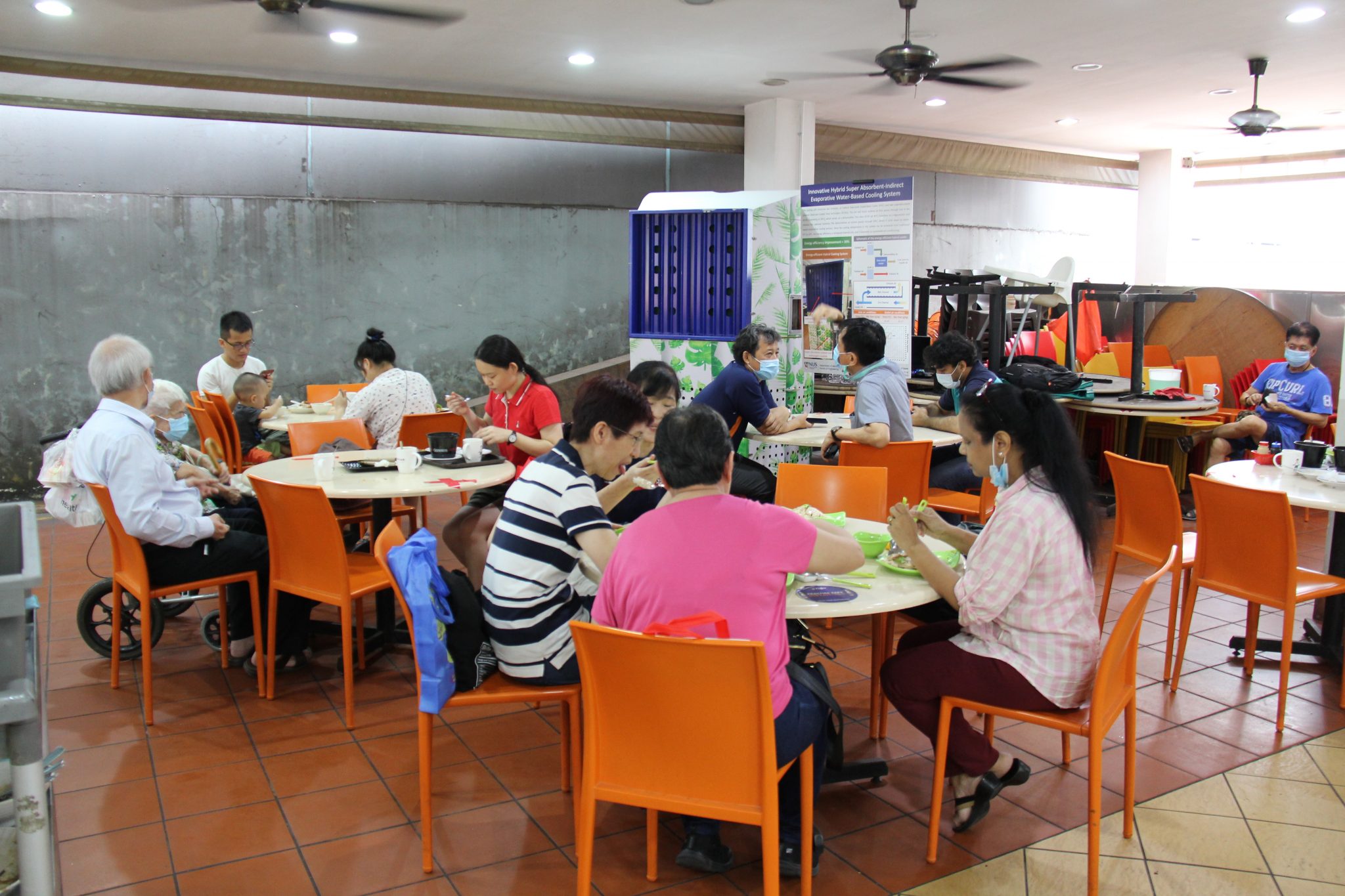 Kopitiam Clementi patrons enjoying the cool air from the hybrid AC. It cools and dehumidifies an area around it within 4 metres.