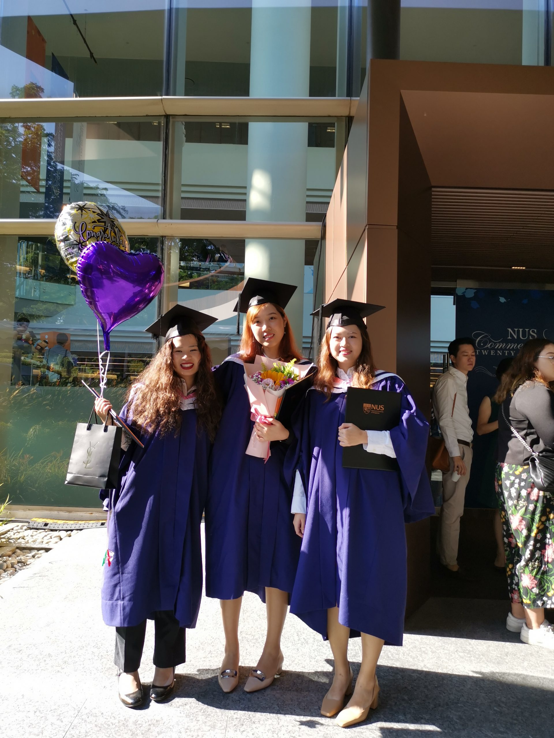 Qiuxia (centre), with fellow graduates at the 2019 NUS Commencement Ceremony.