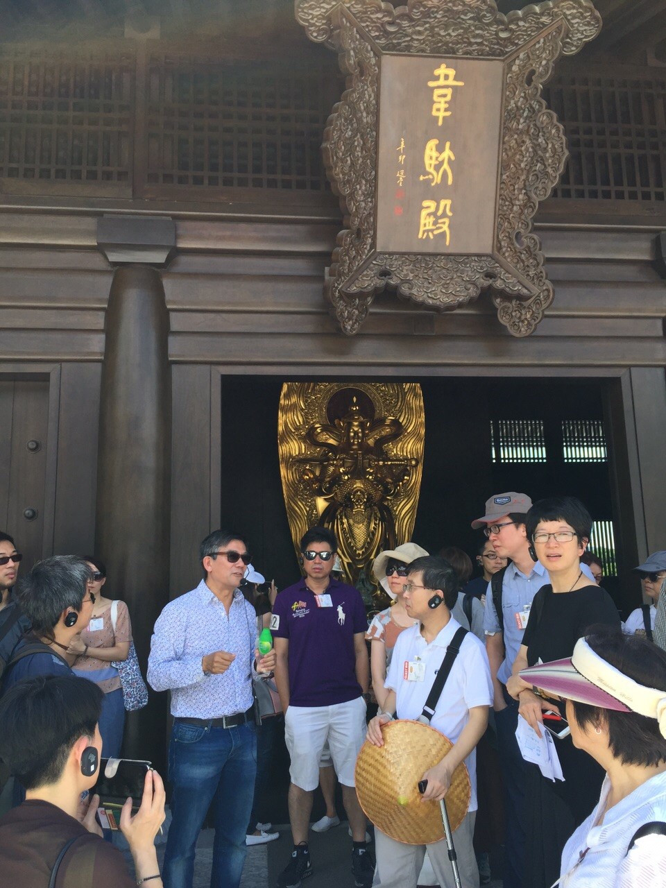 Prof Ho, explaining to visitors the design intricacies of a hall (韦驮殿) within Tsz Shan Monastery (慈山寺) in Hong Kong, which he was in charge of designing.