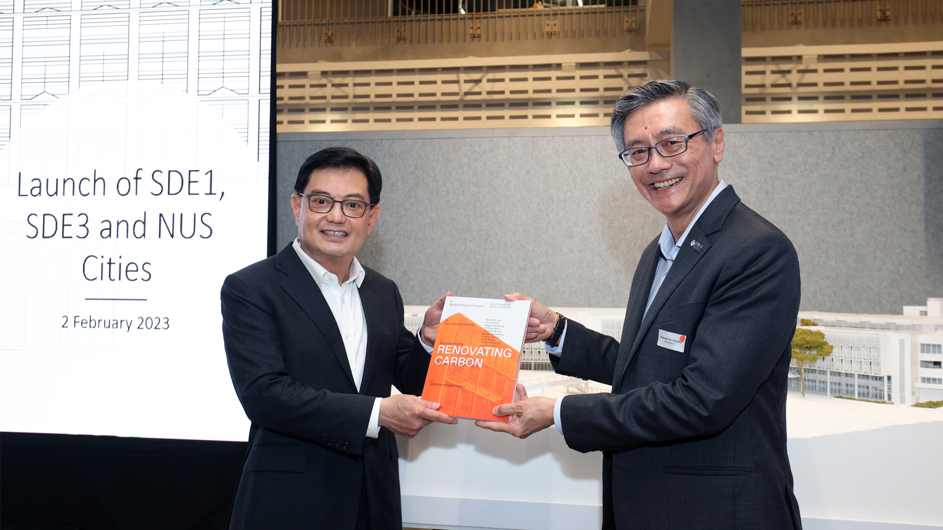 NUS President Prof Tan Eng Chye (right) presenting the book entitled 'Renovating Carbon' to Deputy Prime Minister Heng Swee Keat (left).