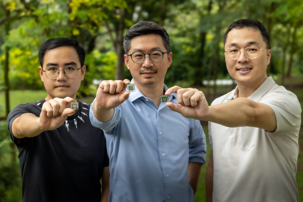 Assistant Professor Hou Yi (centre) with research team members Dr Li Jia (right) and PhD student Liang Haoming (left) holding samples of perovskite solar cells.